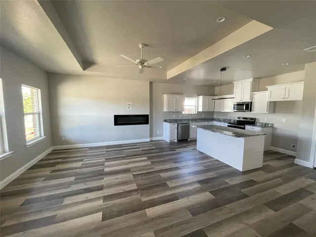 a kitchen with stainless steel appliances kitchen island granite countertop a stove and a refrigerator
