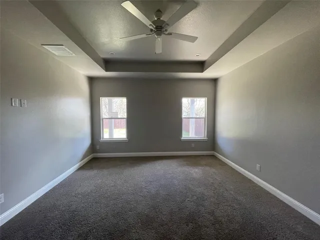 an empty room that has a window and a fan