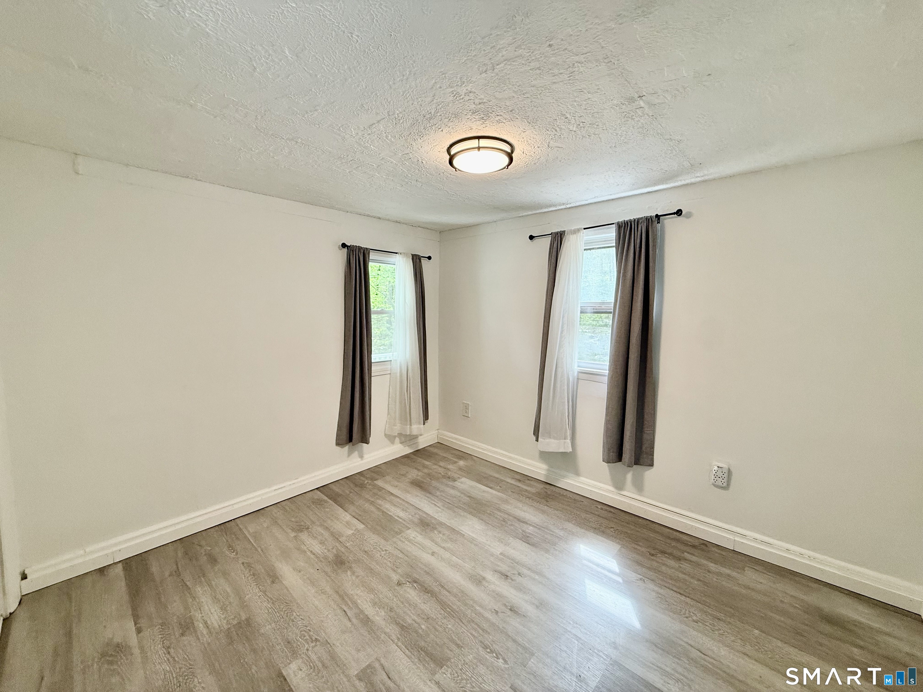 277 Lake Road Andover, CT 06232 - Photo 14 of 18 an empty room with wooden floor and windows