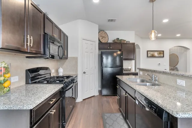 a kitchen with stainless steel appliances granite countertop a sink stove and refrigerator