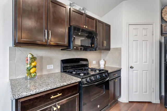 a kitchen with stainless steel appliances granite countertop a stove a microwave and cabinets