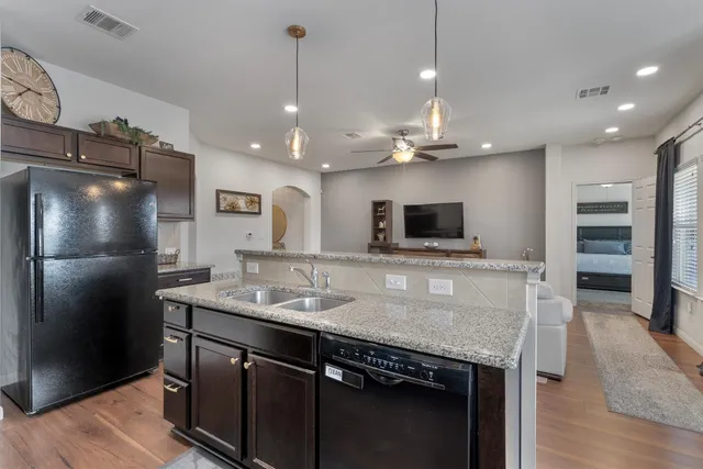 a kitchen with stainless steel appliances granite countertop a sink refrigerator and microwave