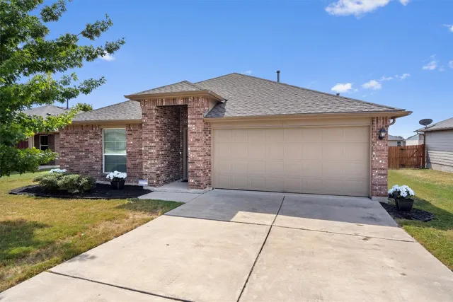 a front view of a house with a garden and yard