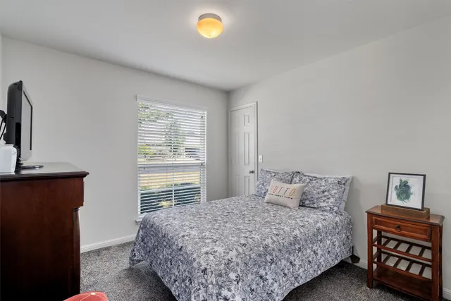 a bedroom with a bed and a dresser with bookshelf