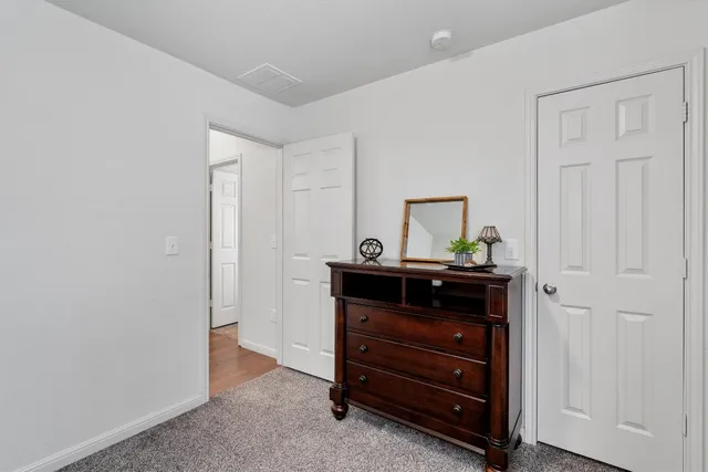 a room that has a dresser and a table in it