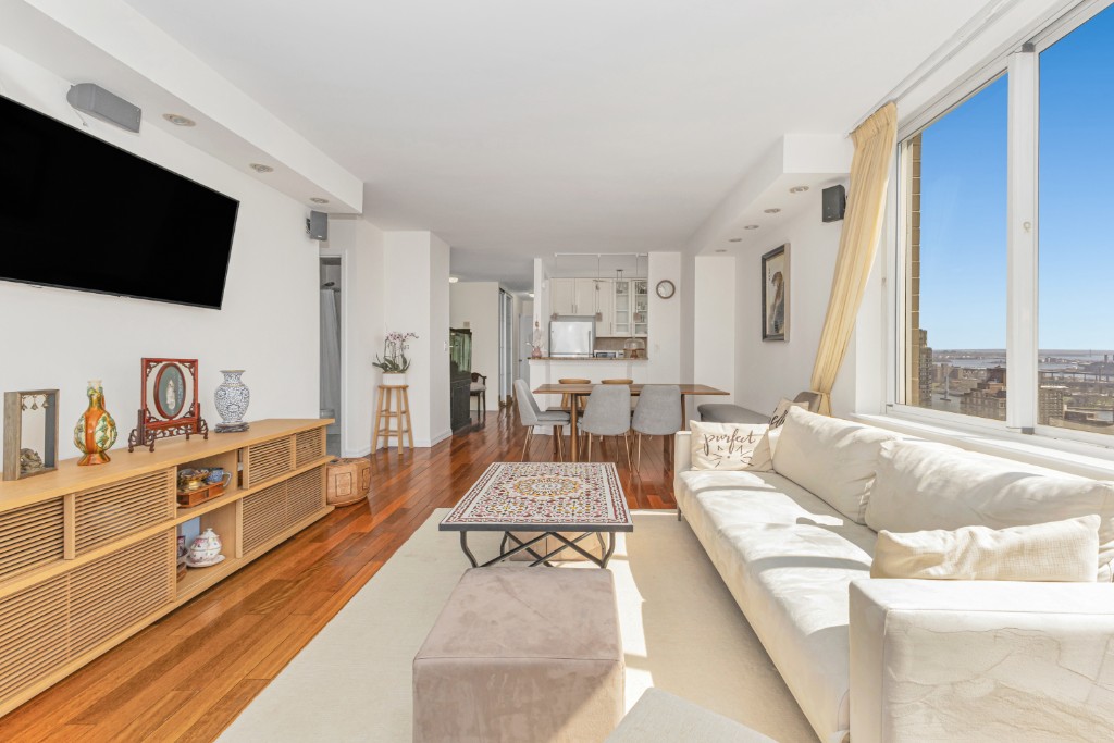 200 East 89th Street, Unit 37D Manhattan, NY 10128 - Photo 10 of 35 a living room with furniture and a flat screen tv