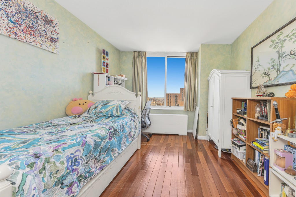 200 East 89th Street, Unit 37D Manhattan, NY 10128 - Photo 13 of 35 a bedroom with a bed and a book shelf