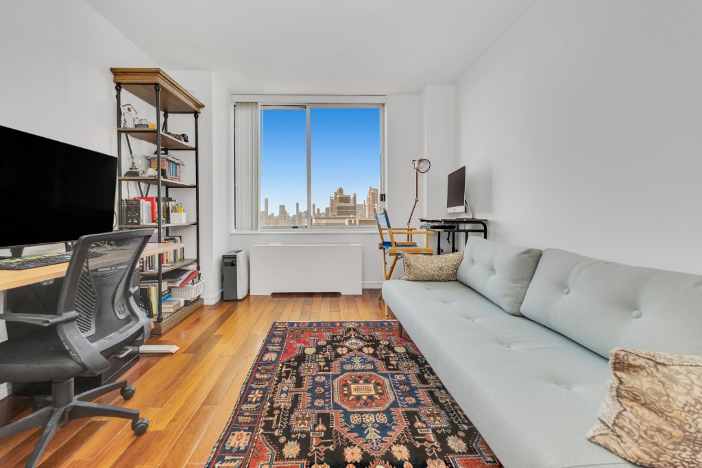 200 East 89th Street, Unit 37D Manhattan, NY 10128 - Photo 14 of 35 a living room with furniture and a flat screen tv