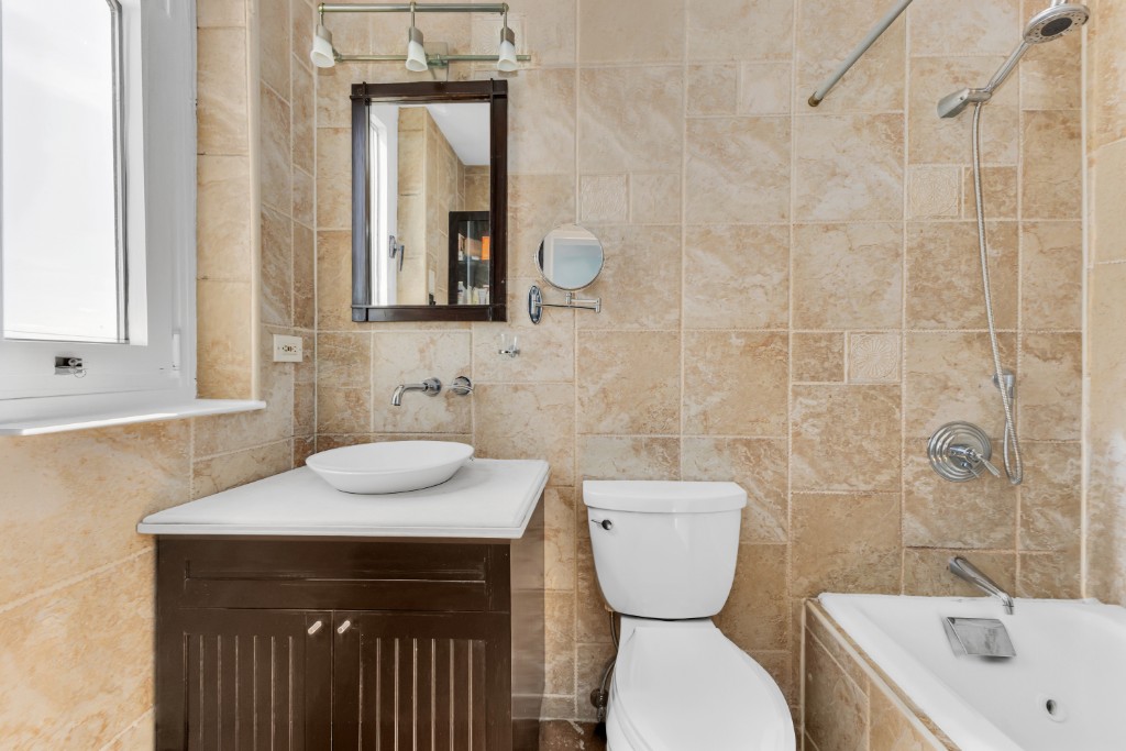 200 East 89th Street, Unit 37D Manhattan, NY 10128 - Photo 16 of 35 a bathroom with a sink a toilet and shower