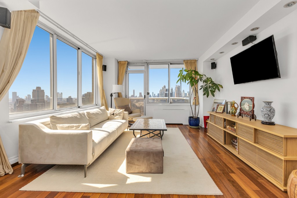 200 East 89th Street, Unit 37D Manhattan, NY 10128 - Photo 1 of 35 a living room with furniture and a flat screen tv