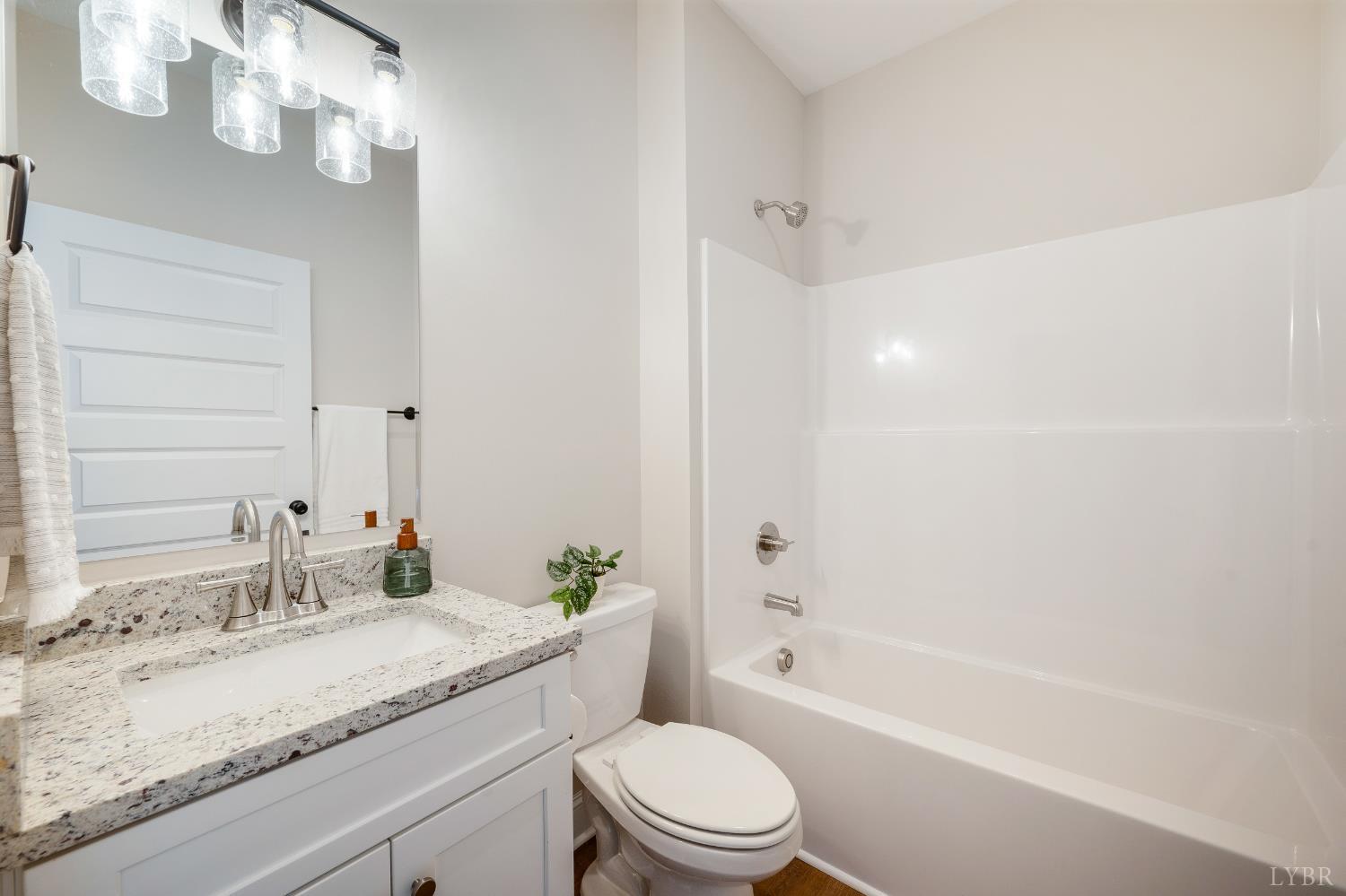 10528 Leesville Road Lynch Station, VA 24571 - Photo 29 of 58 a bathroom with a granite countertop sink a toilet and bathtub