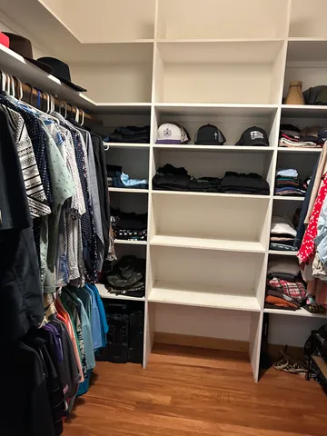 a view of walk in closet with clothes and shoes