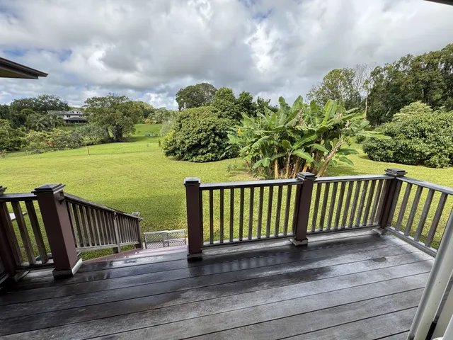 a balcony with wooden floor table and chairs