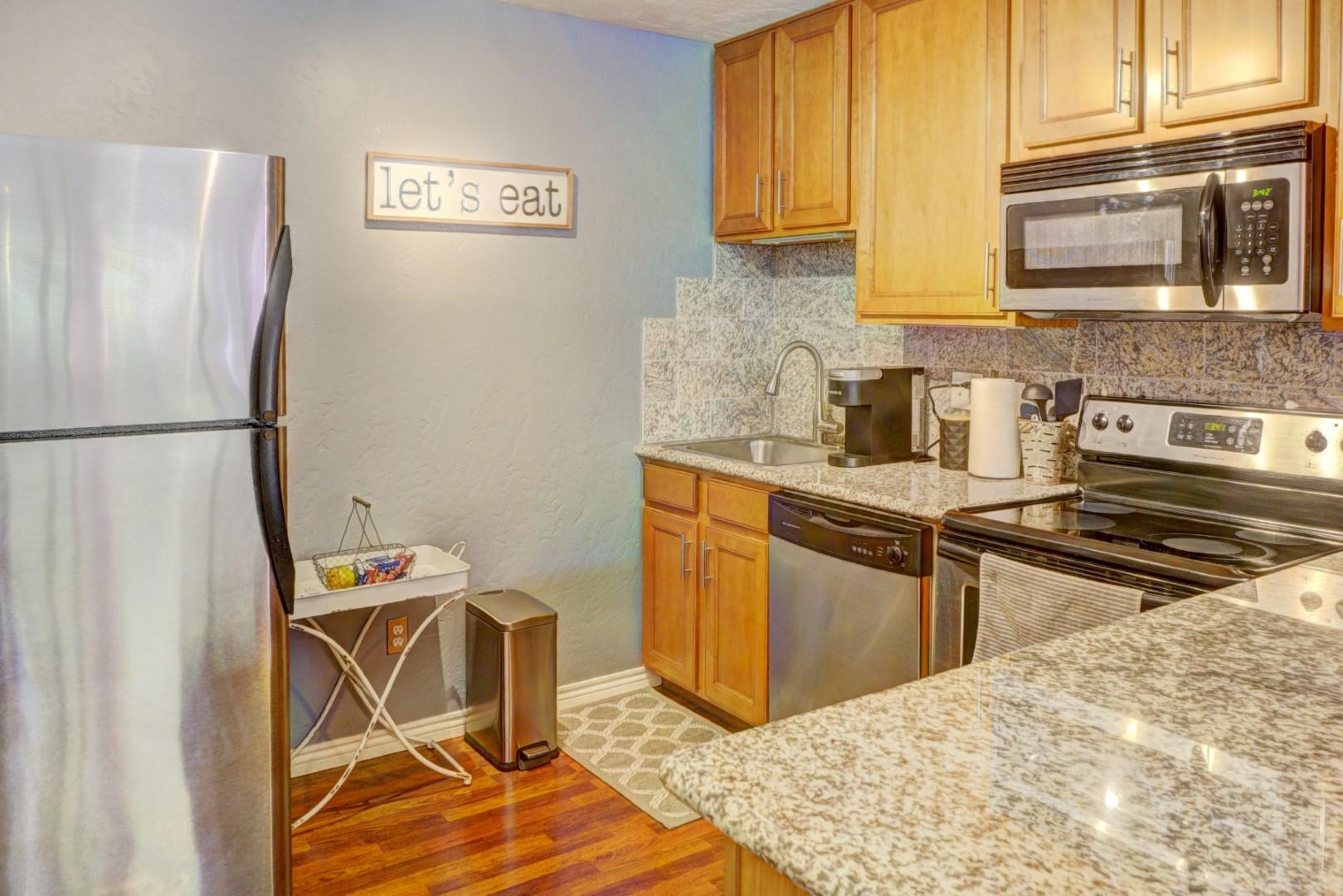 948 Northern Way, Unit 4 Grand Junction, CO 81506 - Photo 6 of 15 a kitchen with stainless steel appliances granite countertop a refrigerator a stove a sink and a microwave