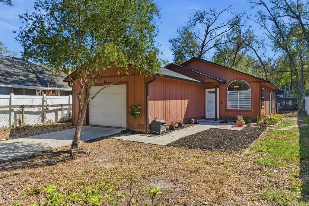 a view of a house with backyard and trees