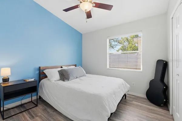 a bedroom with bed and wooden floor