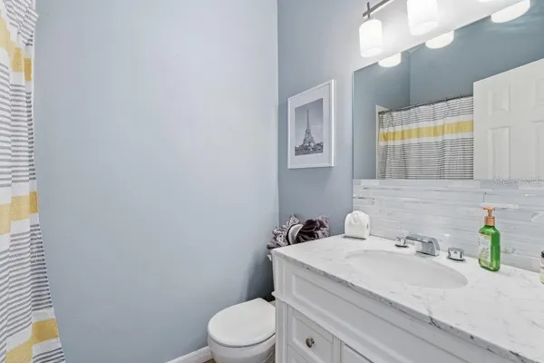 a bathroom with a granite countertop toilet sink and mirror