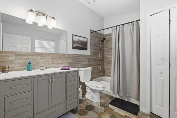 a bathroom with a sink a toilet a mirror and shower