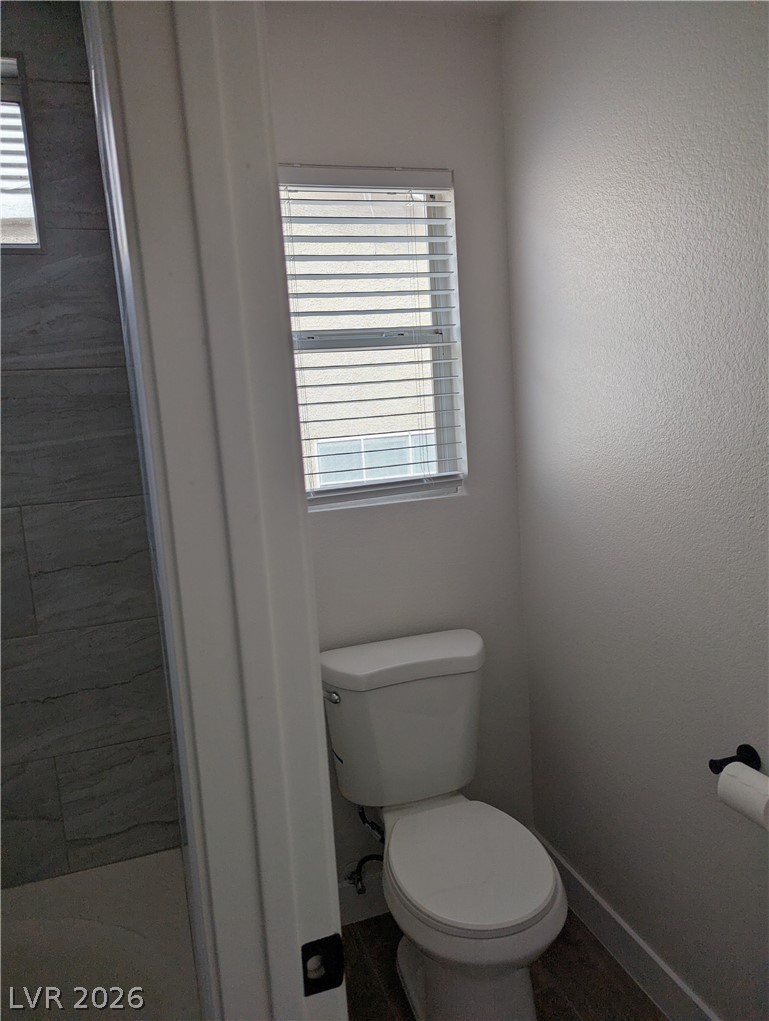 327 Perry Ellis Drive Henderson, NV 89014 - Photo 49 of 54 This clean bathroom features wood flooring and a window with blinds for natural light.