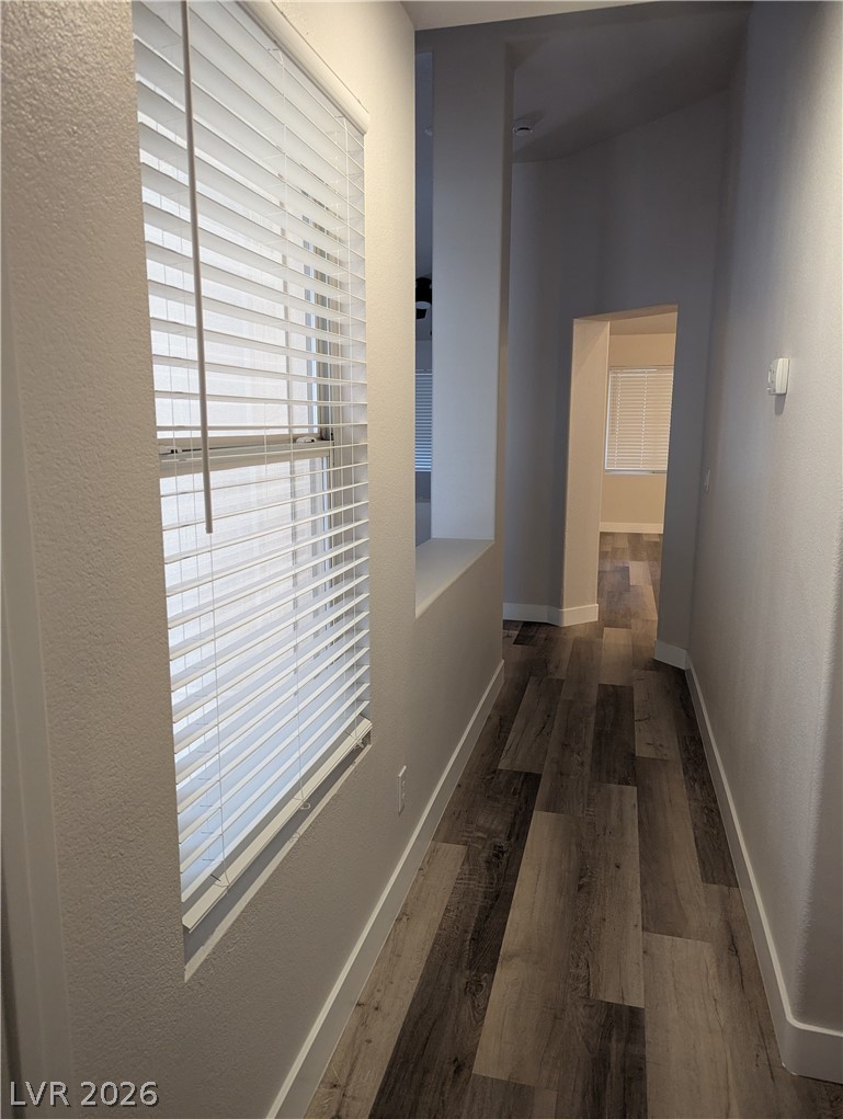 327 Perry Ellis Drive Henderson, NV 89014 - Photo 50 of 54 A well-lit hallway features wood flooring and bright natural light.