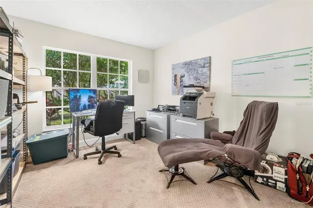 a view of a workspace with furniture and a window