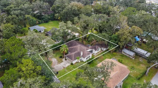 an aerial view of a house with a yard and lake view