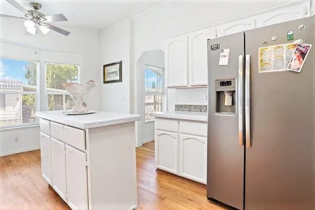 a kitchen with white cabinets and refrigerator