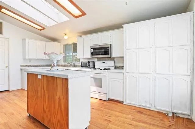 a kitchen with white cabinets and black appliances