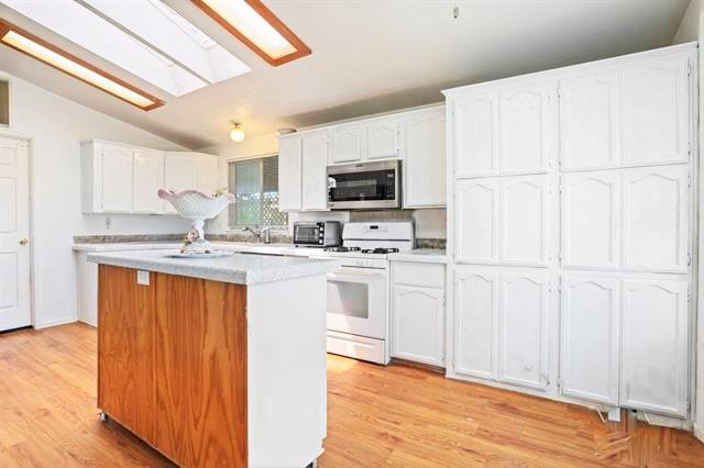 708 Spindrift Drive, Unit 708 San Jose, CA 95134 - Photo 8 of 18 a kitchen with white cabinets and black appliances