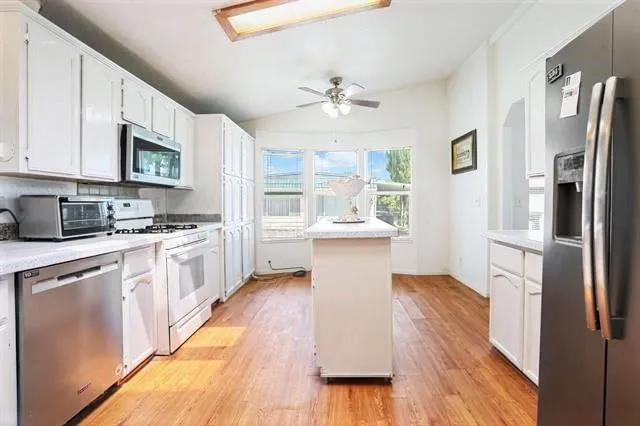 a kitchen with stainless steel appliances a refrigerator sink and cabinets
