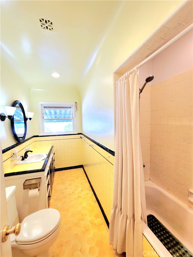 2427 Pine Avenue Long Beach, CA 90806 - Photo 20 of 24 a bathroom with a granite countertop sink toilet and shower