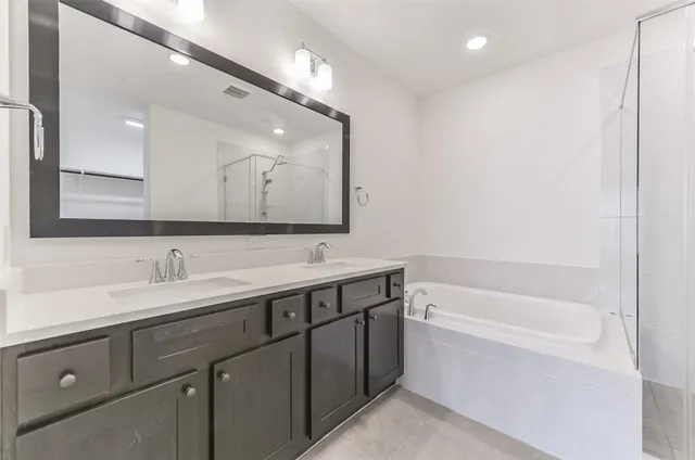 a bathroom with a bathtub a sink and mirror