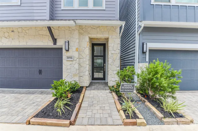 a stone house with potted plants in front of door