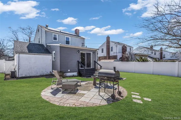 a view of a chair and table in backyard of the house