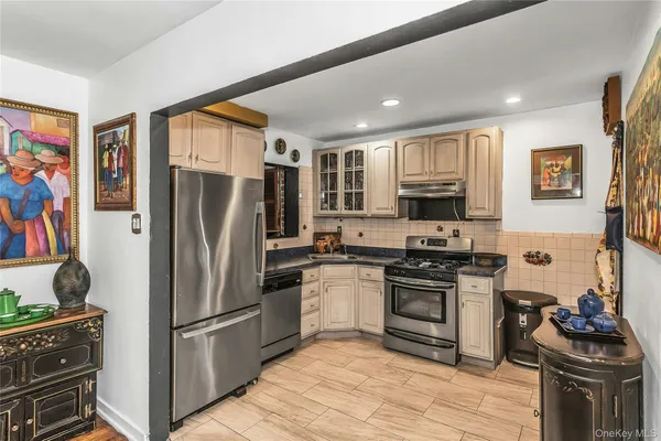 a kitchen with stainless steel appliances granite countertop a refrigerator stove and sink