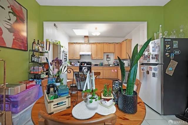 a kitchen with stainless steel appliances kitchen island granite countertop a refrigerator a stove top oven a sink and a dining table with the view