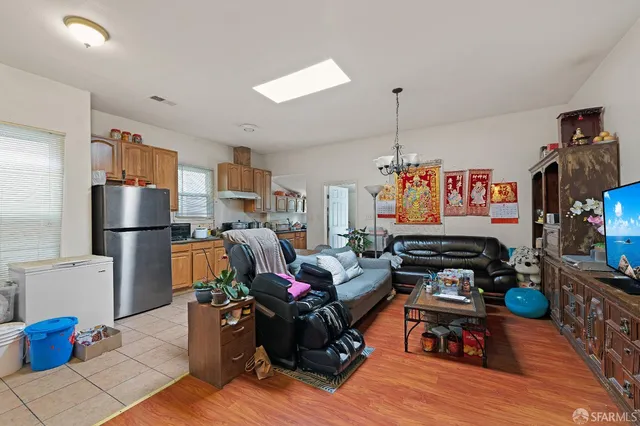 a living room with furniture kitchen view and a large window