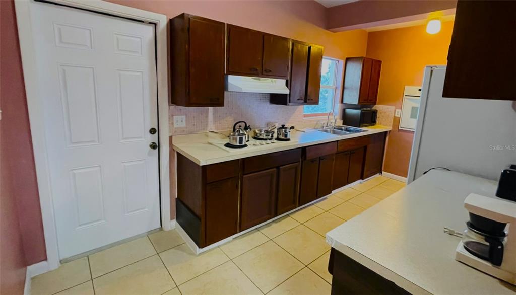 554 Lindley Terrace Port Charlotte, FL 33952 - Photo 4 of 57 a kitchen with a sink and a refrigerator