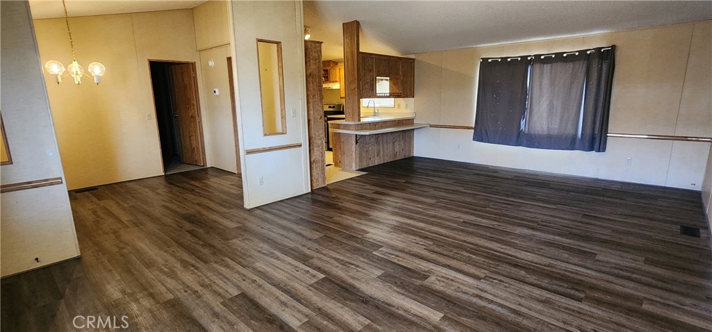 3589 West Wells Road, Unit 99 Blythe, CA 92225 - Photo 4 of 26 a view of a refrigerator in kitchen and wooden floor