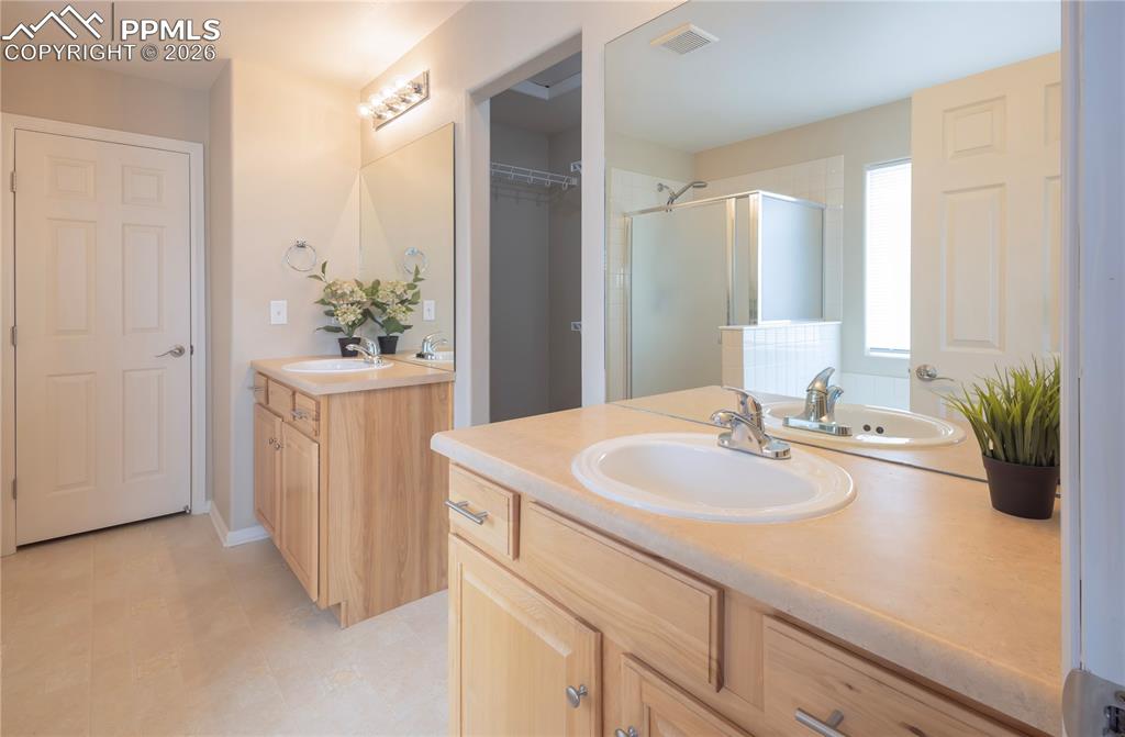 4815 Harrier Ridge Drive Colorado Springs, CO 80916 - Photo 13 of 33 Full bath with two vanities and a shower stall