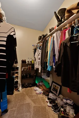 a view of walk in closet with clothes and shoes
