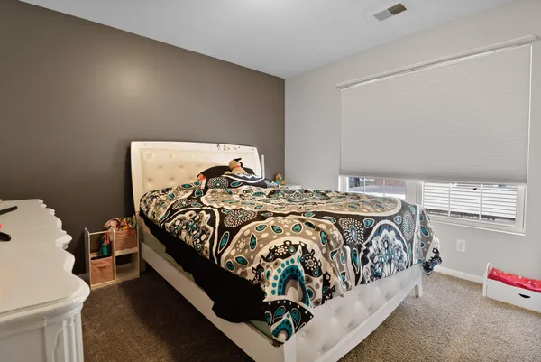 a bed sitting in a bedroom next to a larger window