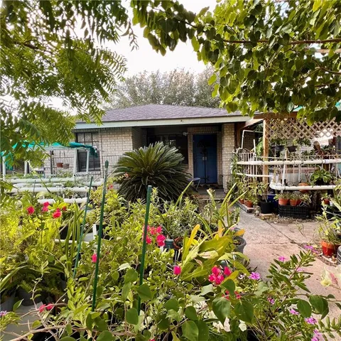 a flower garden is sitting in front of house