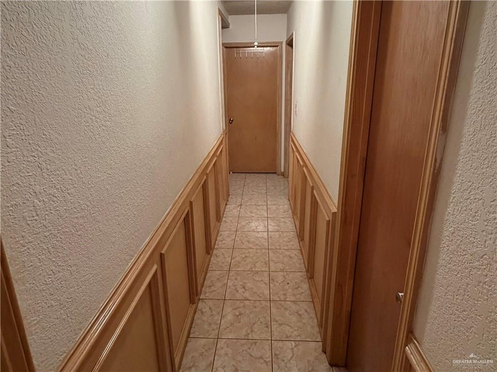 937 Whitewing Street Roma, TX 78584 - Photo 4 of 14 Hallway featuring a textured wall and light tile patterned flooring