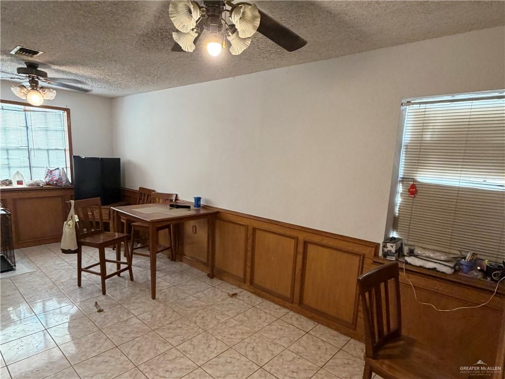 937 Whitewing Street Roma, TX 78584 - Photo 6 of 14 Dining space featuring a ceiling fan, a textured ceiling, and light tile patterned floors