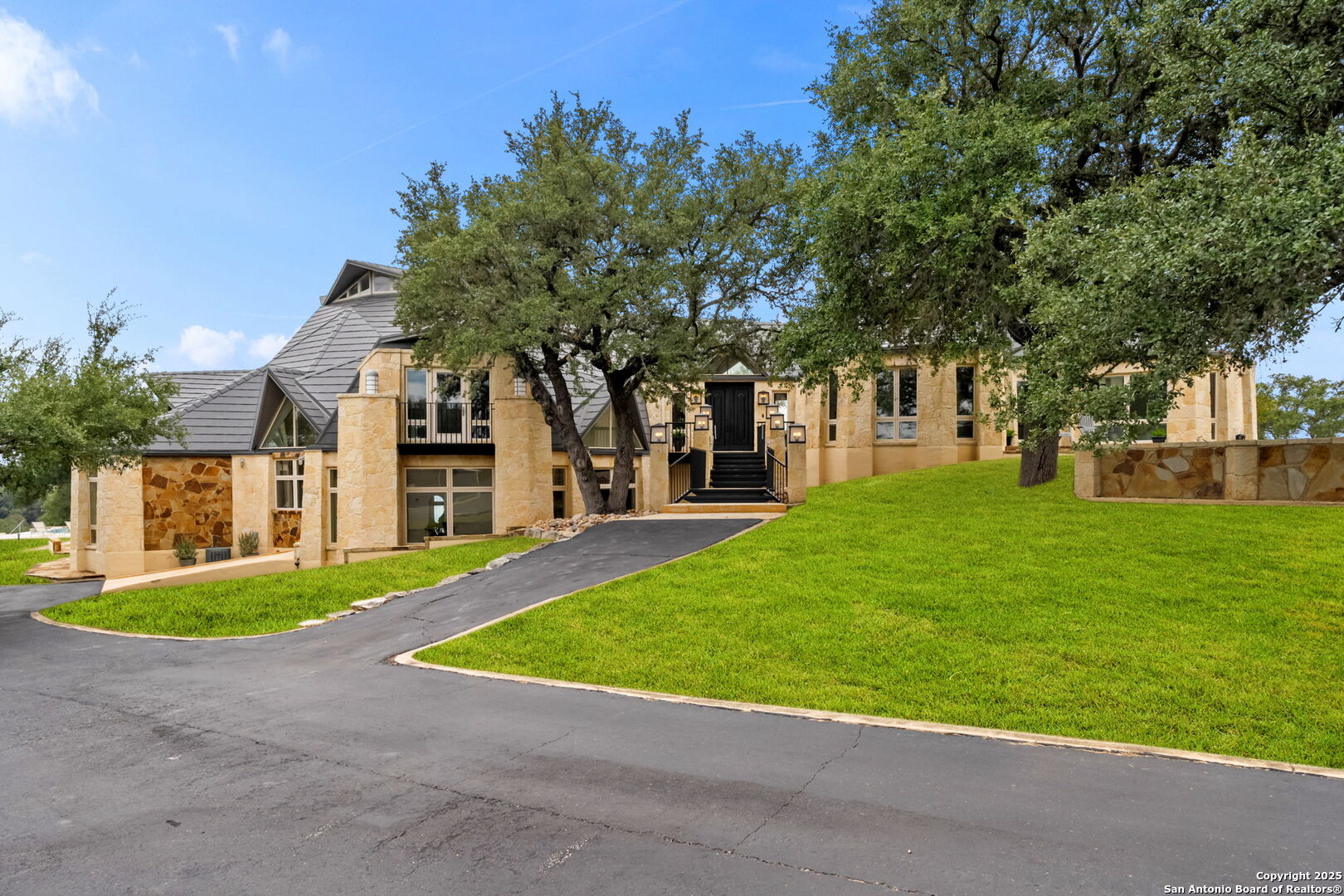 a view of a building with a big yard and large trees
