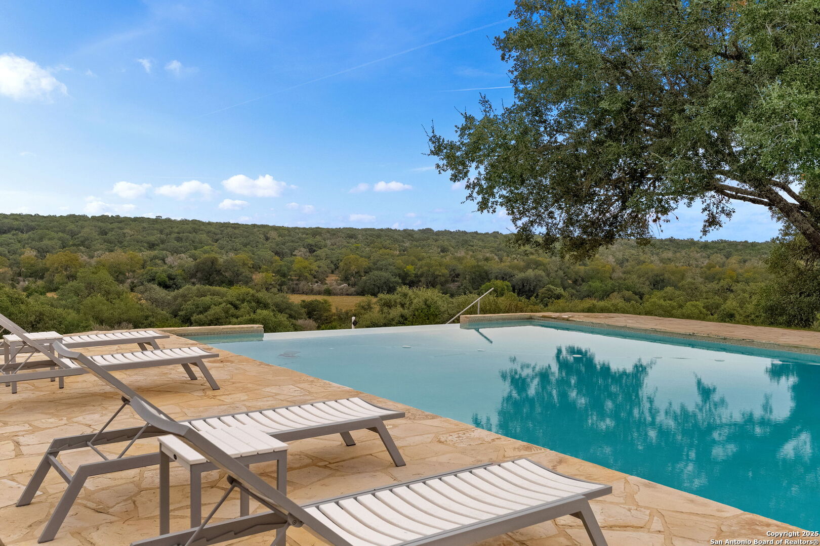 117 Clear Spring Drive Boerne, TX 78006 - Photo 7 of 54 a view of a lake with a table and chairs under an umbrella