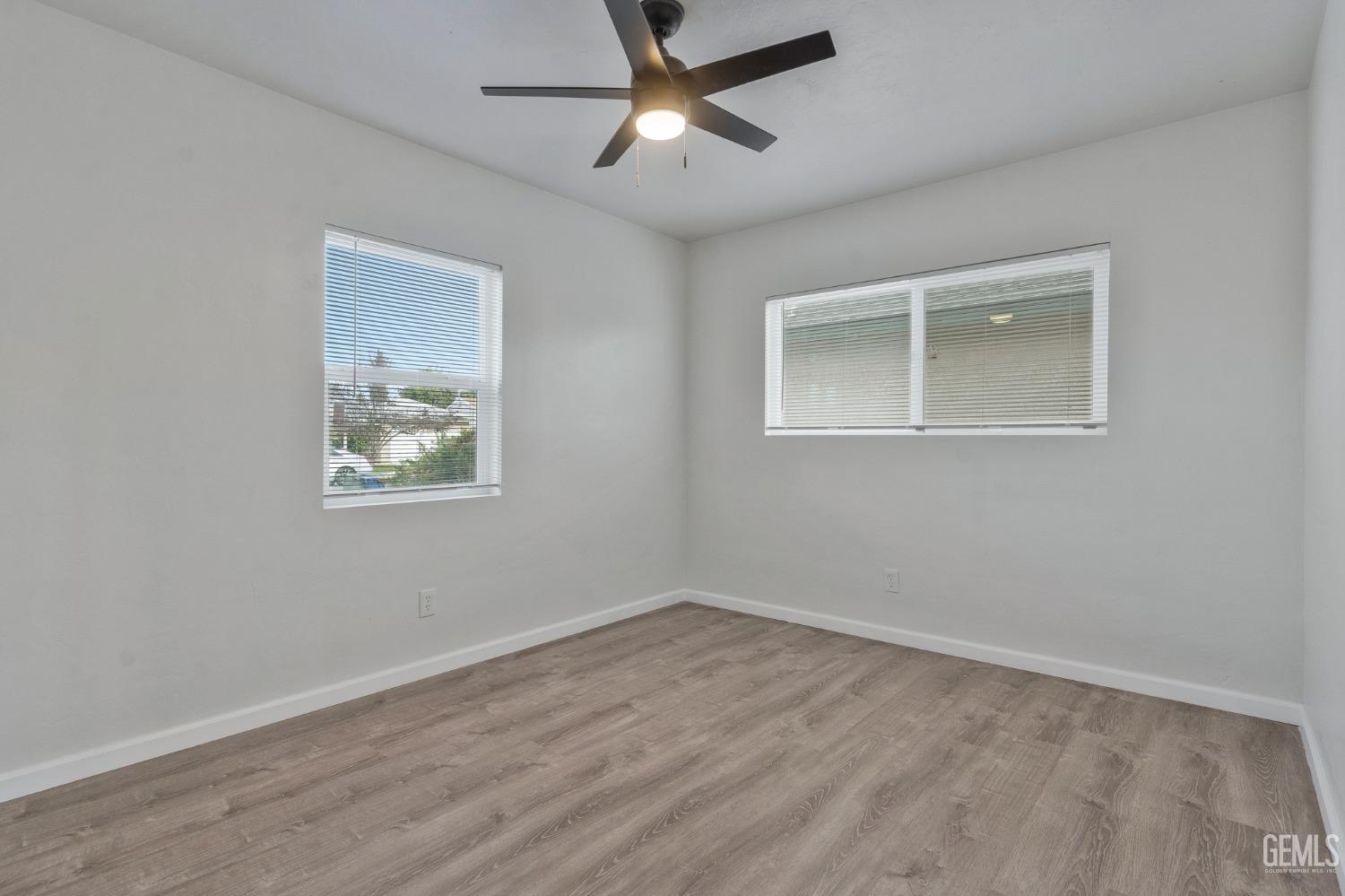 Undisclosed Address Bakersfield, CA 93304 - Photo 17 of 29 a view of an empty room with a window and wooden floor