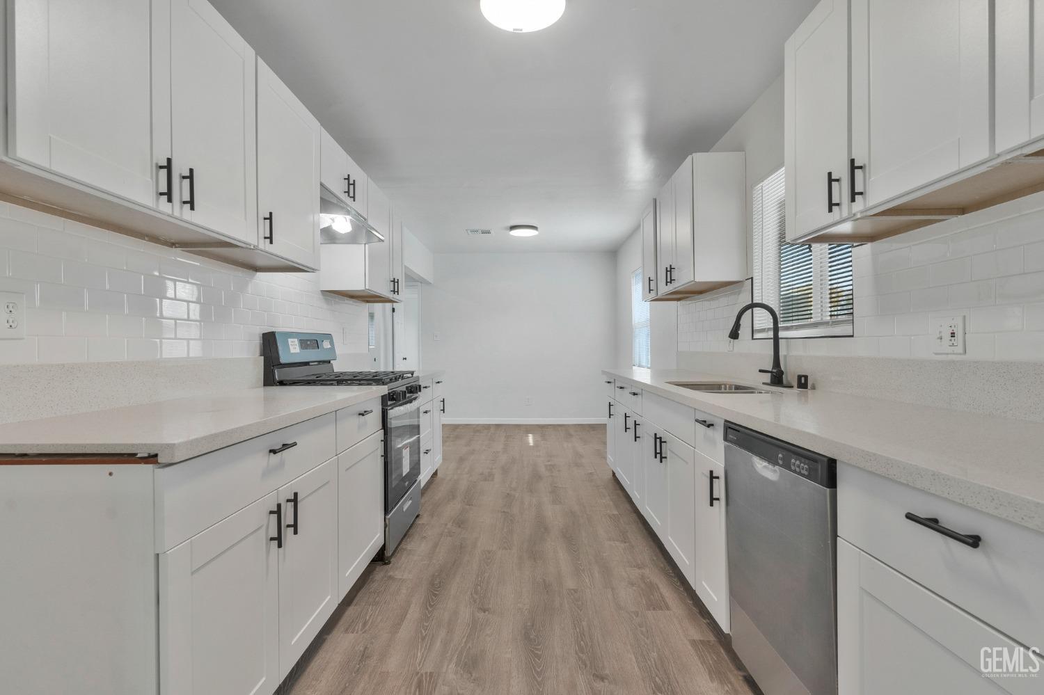 Undisclosed Address Bakersfield, CA 93304 - Photo 19 of 29 a large kitchen with cabinets a sink and wooden floor