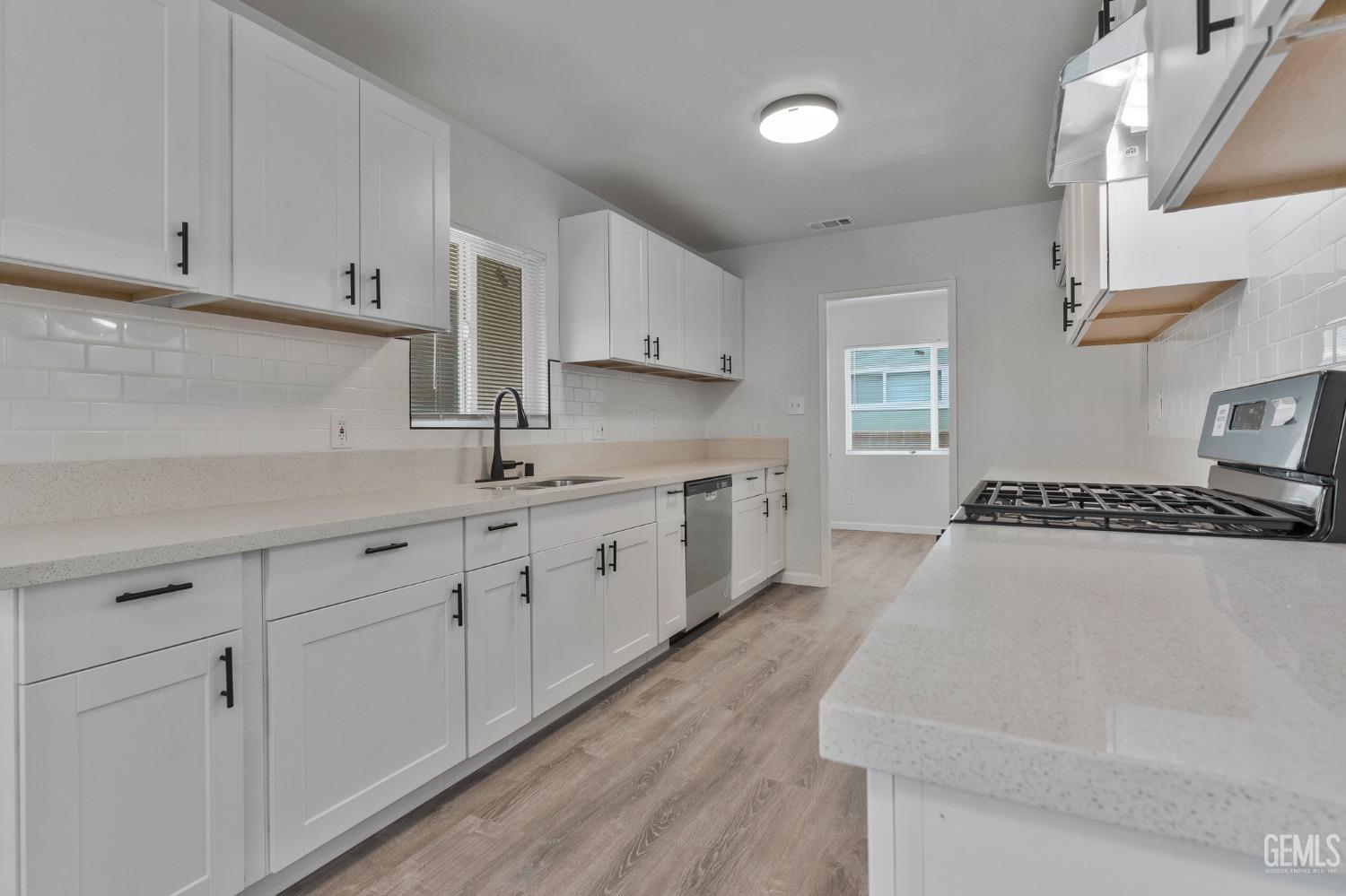 Undisclosed Address Bakersfield, CA 93304 - Photo 21 of 29 a kitchen with sink stove and cabinets